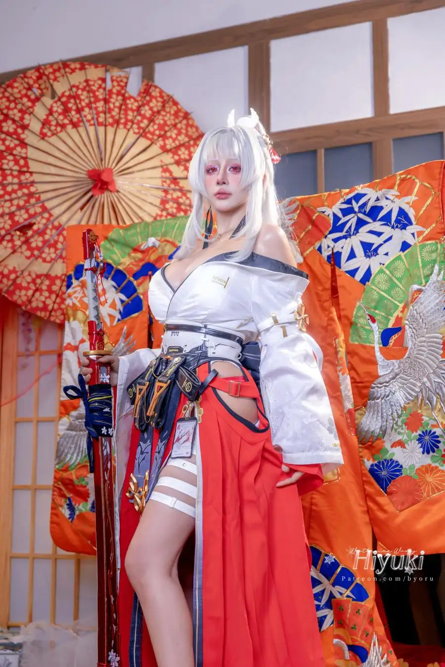 Byoru 白发红白服装持刀站姿,背景为纸伞与彩色织物