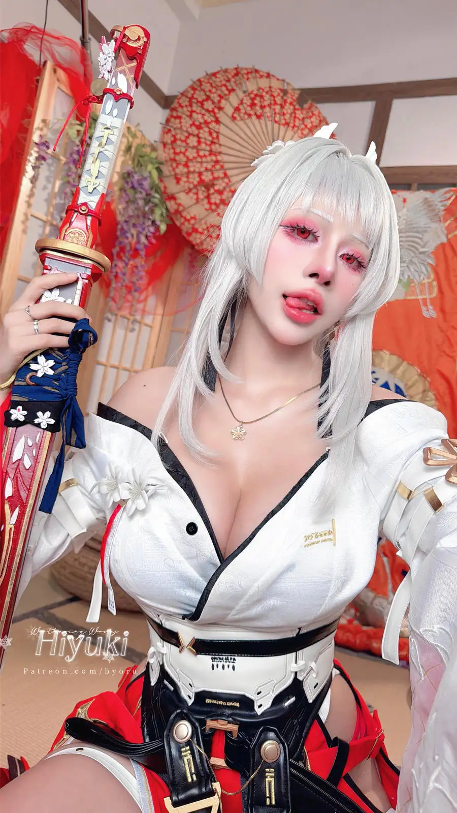 Byoru 白发红白造型手持装饰刀柄的近景,背后是花纹纸伞