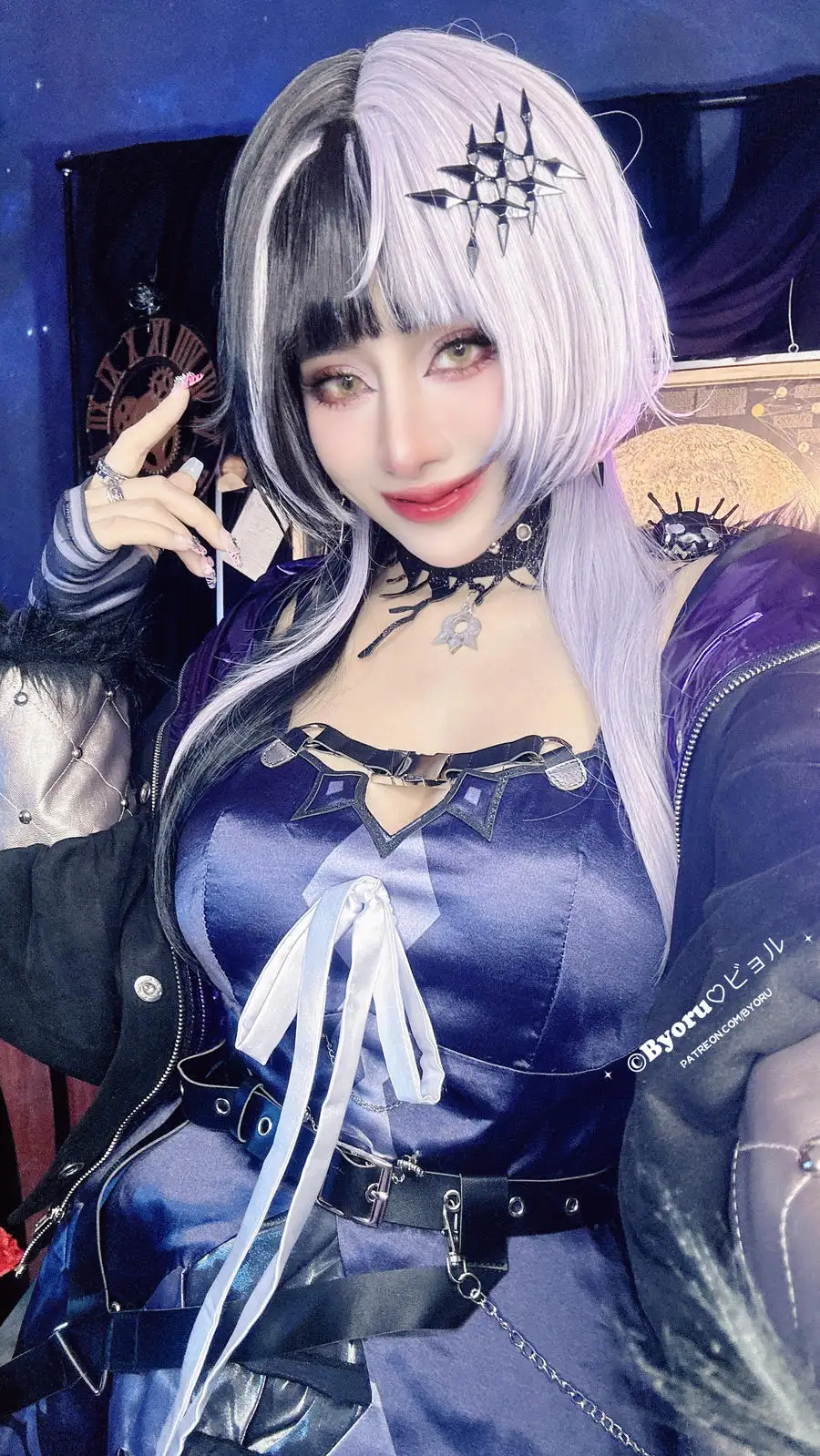 Byoru 黑白双色发与紫色服装近景,手抬至太阳穴旁