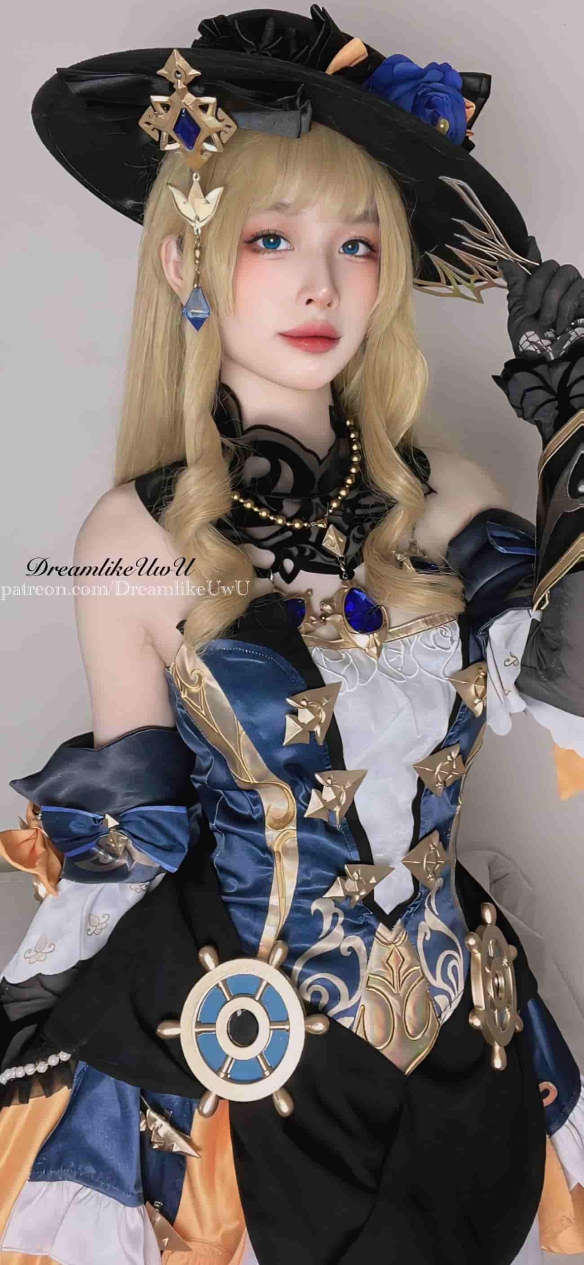 DreamlikeUwU金色长卷发戴黑色宽檐帽配蓝玫瑰,蓝金束腰礼服上挂着舵轮造型配件