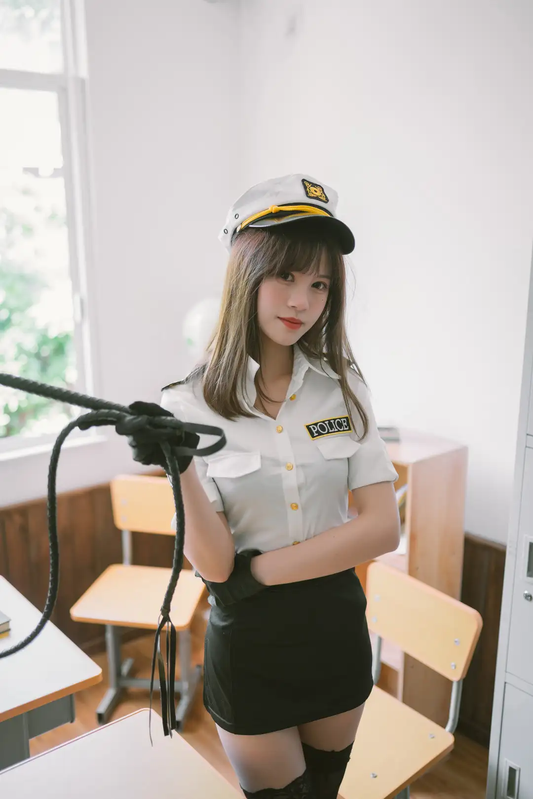 千反田鹿子身穿白衬衫黑色短裙的警官造型,戴白色大檐帽站在明亮的教室里
