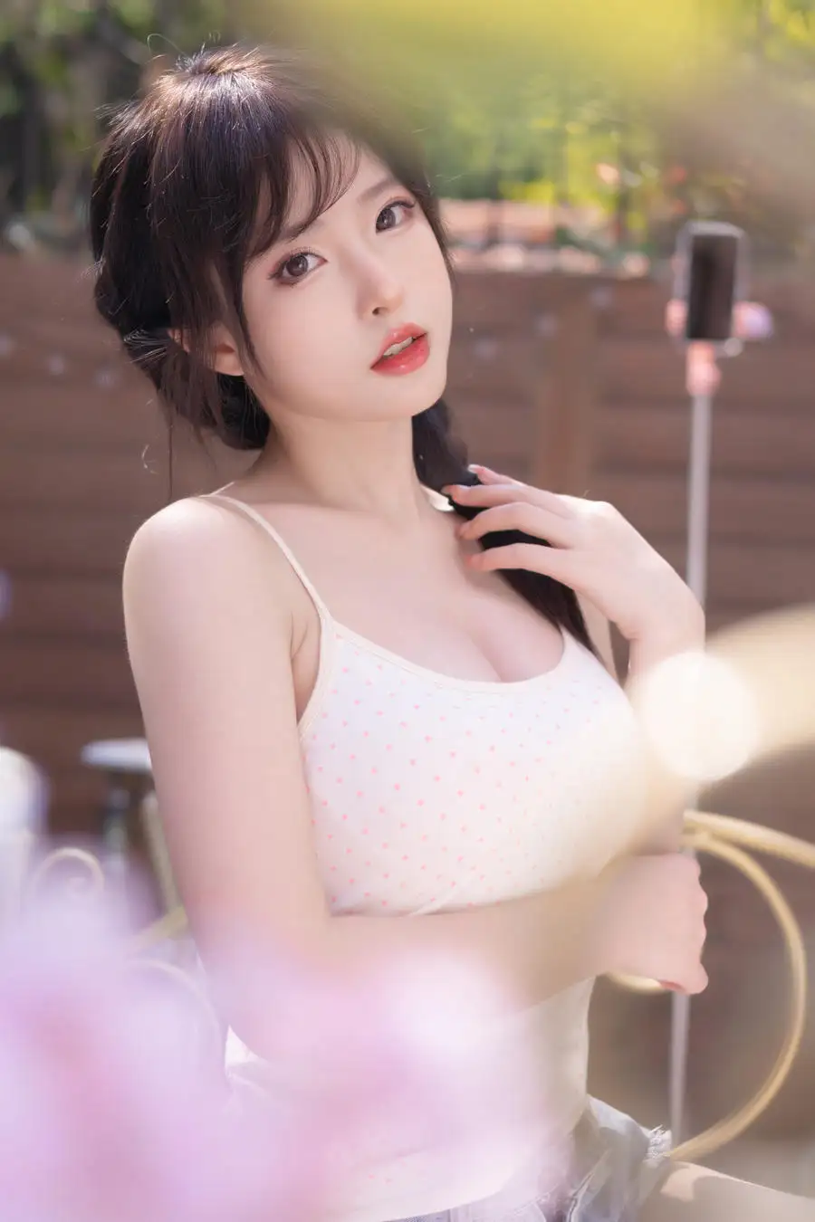 清水由乃在花朵前扶着辫子,白色上衣近景保留手部动作
