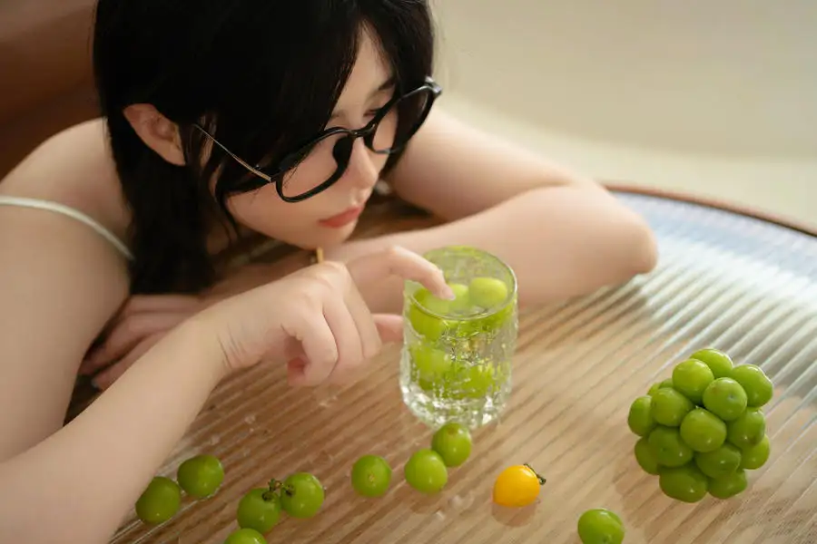 眼酱大魔王戴眼镜伏近桌面,前方有葡萄和装着绿色果实的玻璃杯