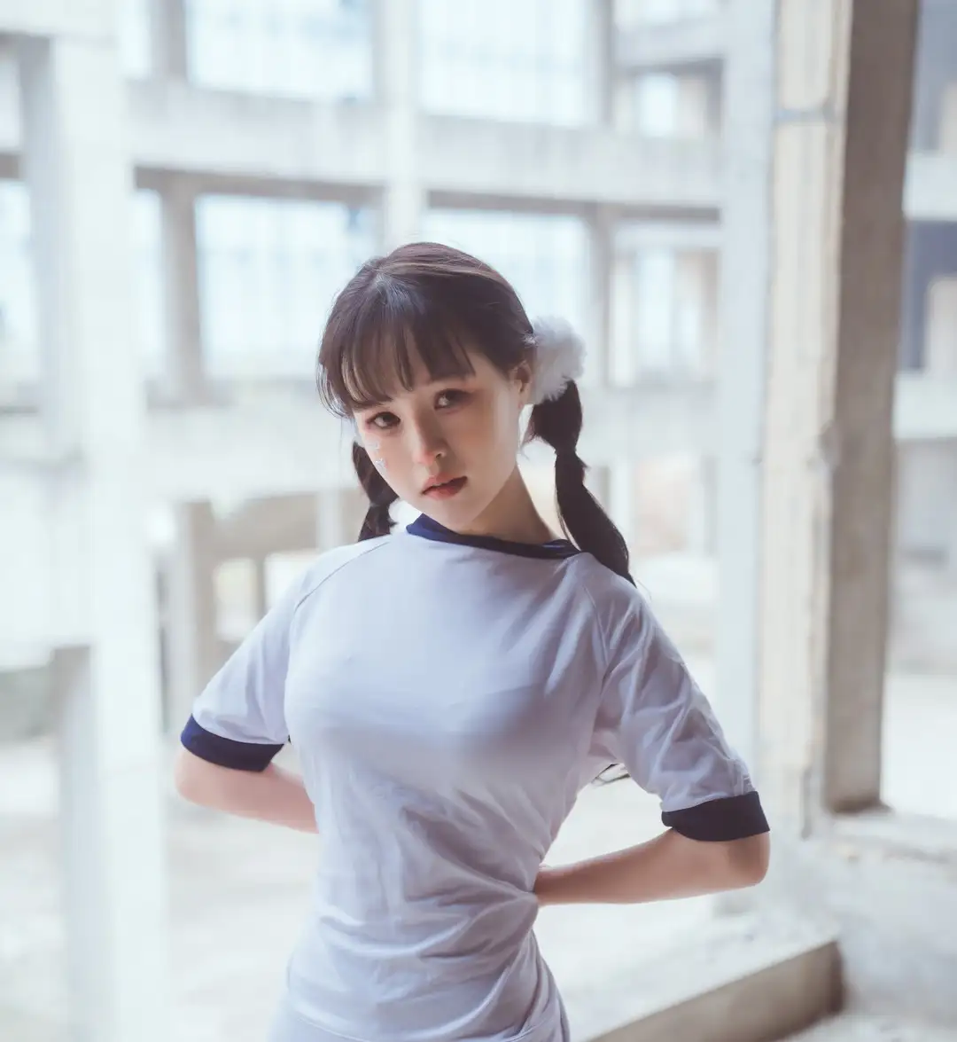 晕崽白色短袖体操服配双马尾,站在高光灌入的走廊窗边