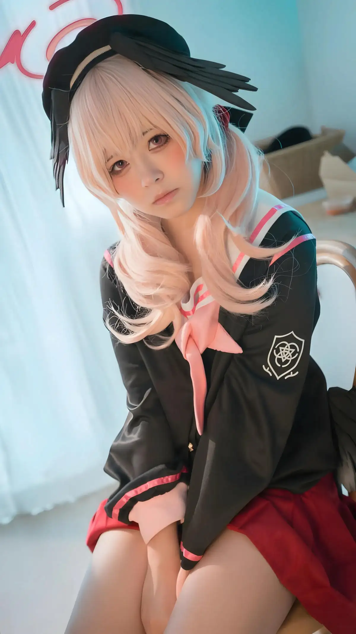 浅粉发人物戴黑色帽饰,穿黑红学院风服装。
