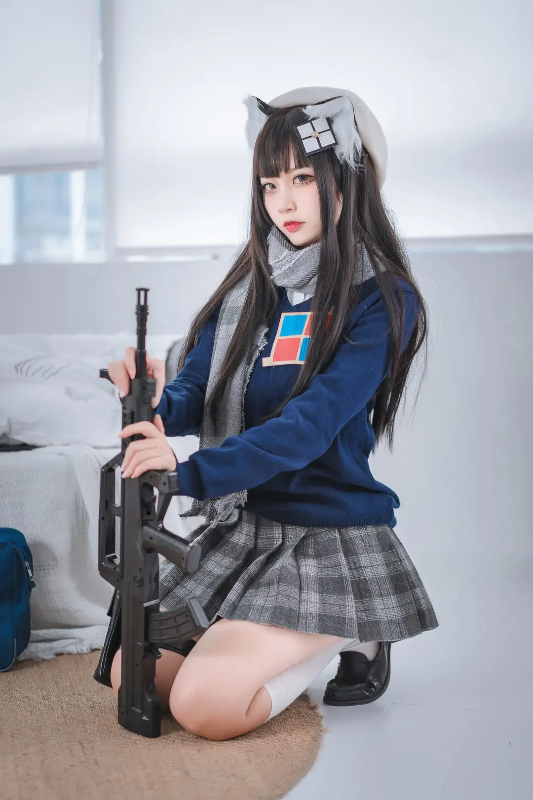 二佐黑色长发戴猫耳与白色贝雷帽,身穿藏青毛衣配灰格百褶裙白袜,手持步枪道具呈跪姿