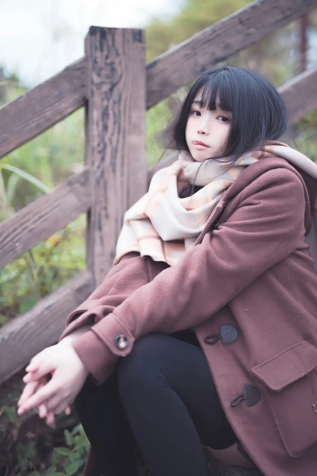 落落Raku黑色长发扎起,穿白色水手服上衣与深色裙装,户外绿植和水面背景