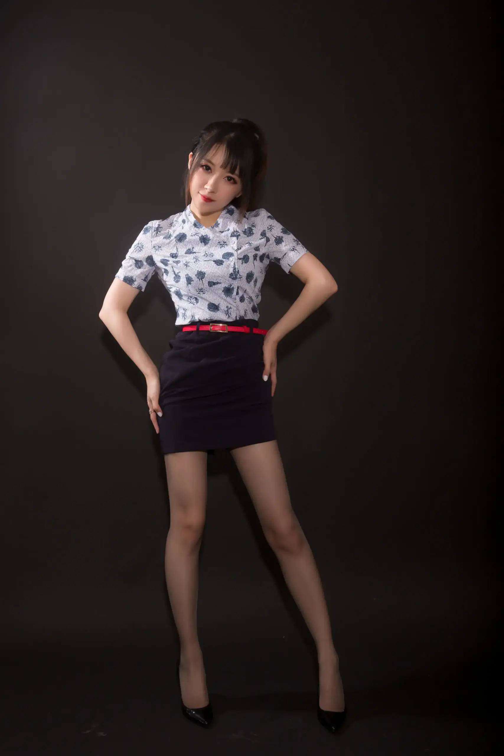 小女巫露娜深色马尾,浅蓝灰图案短袖衬衫与深红腰带,黑丝配亮面尖头高跟,黑背景下笑看镜头 小女巫露娜深色马尾,浅蓝灰图案短袖衬衫与深红腰带,黑丝配亮面尖头高跟,黑背景下笑看镜头
