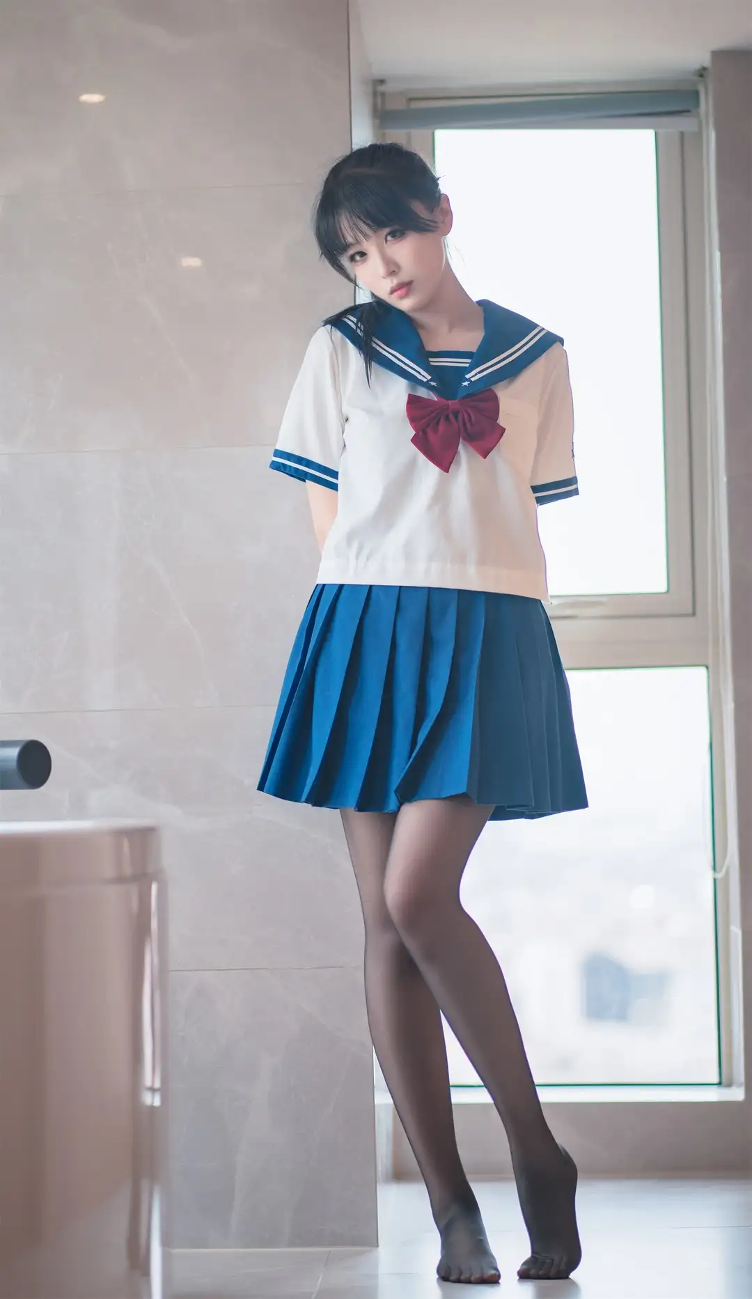 轩萧学姐蓝黑长发穿白蓝水手服与蓝色百褶裙,站在明亮窗边